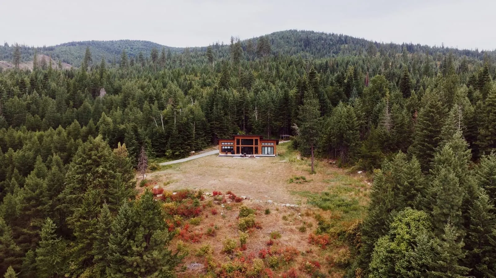 Aerial view of a small building in a forest clearing