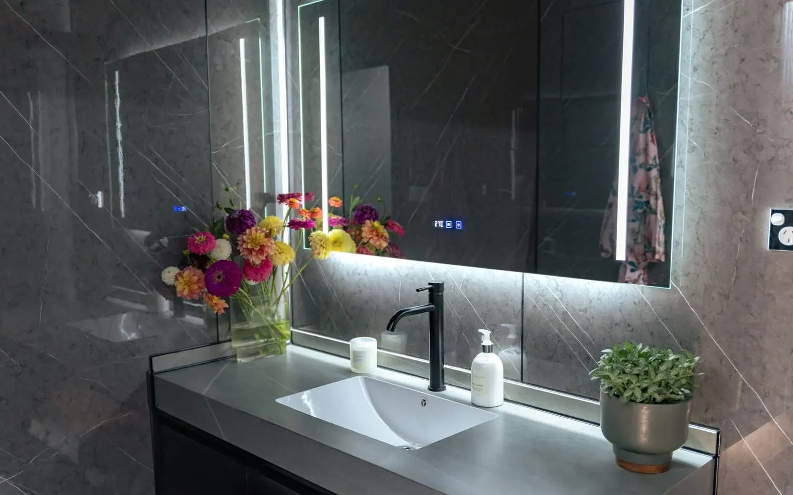 Aluxria capsule bathroom with backlit mirror and stone basin