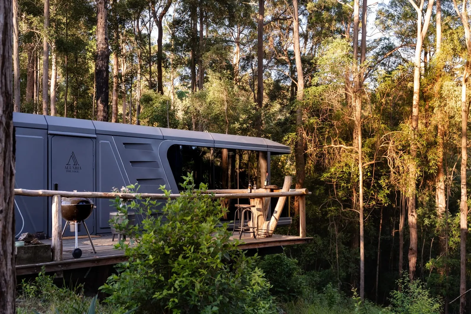 Aluxria capsule with deck in a forest clearing