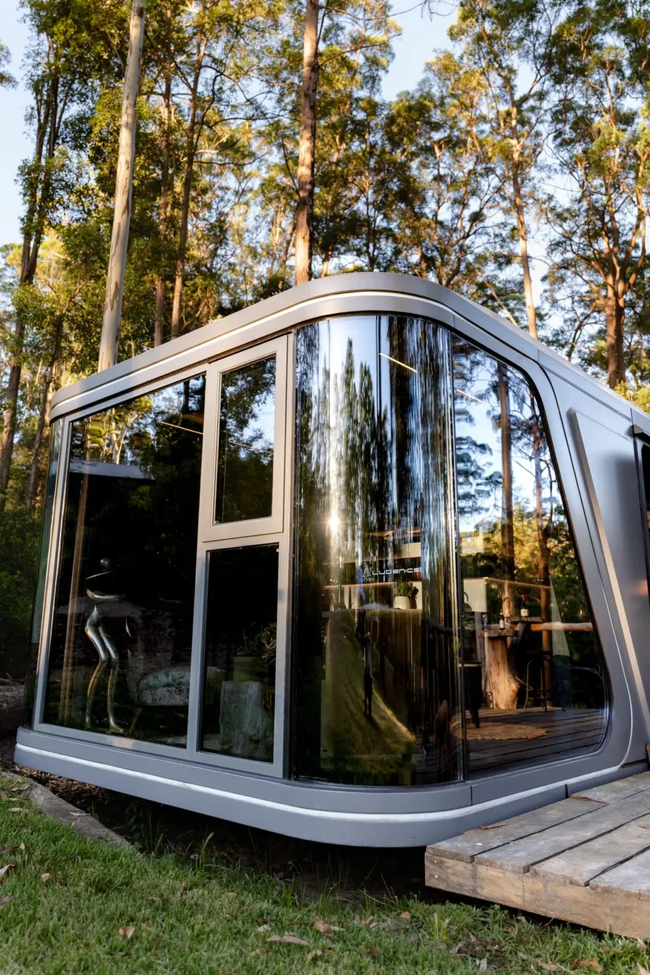 Aluxria capsule with curved glass end in a forest