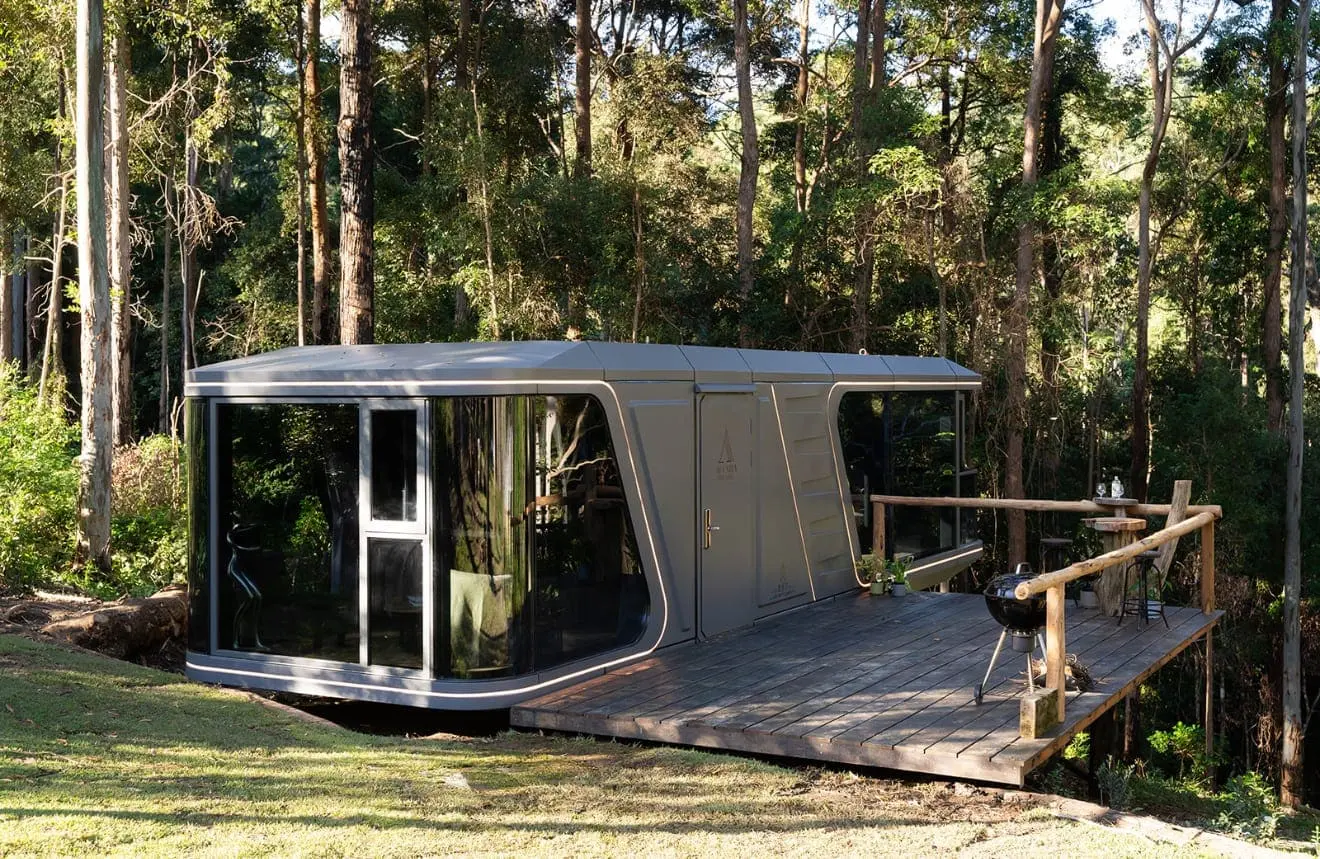 Aluxria capsule with timber deck in a forest setting